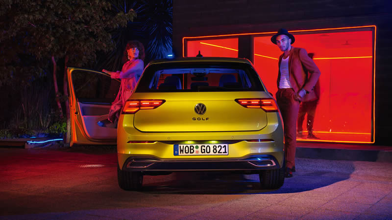 Muž a žena v noci vystupují z vozu Volkswagen Golf 8