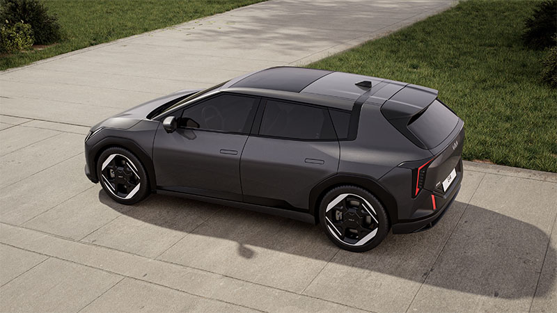 Boční pohled na tmavě šedý elektrický vůz Kia EV4 GT-Line zaparkovaný na ulici