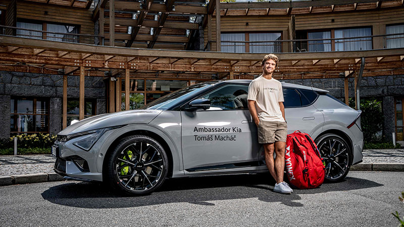 Tenista Tomáš Macháč u elektromobilu Kia EV6 GT s tenisovou taškou