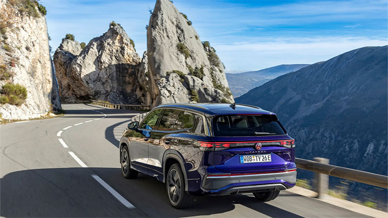 Nový modrý Volkswagen Tayron projíždějících se po horských silnicích